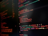 A computer screen displaying colorful lines of code primarily written in JavaScript. The background is dark with code highlighted in various colors like orange, green, and red to differentiate syntax elements.