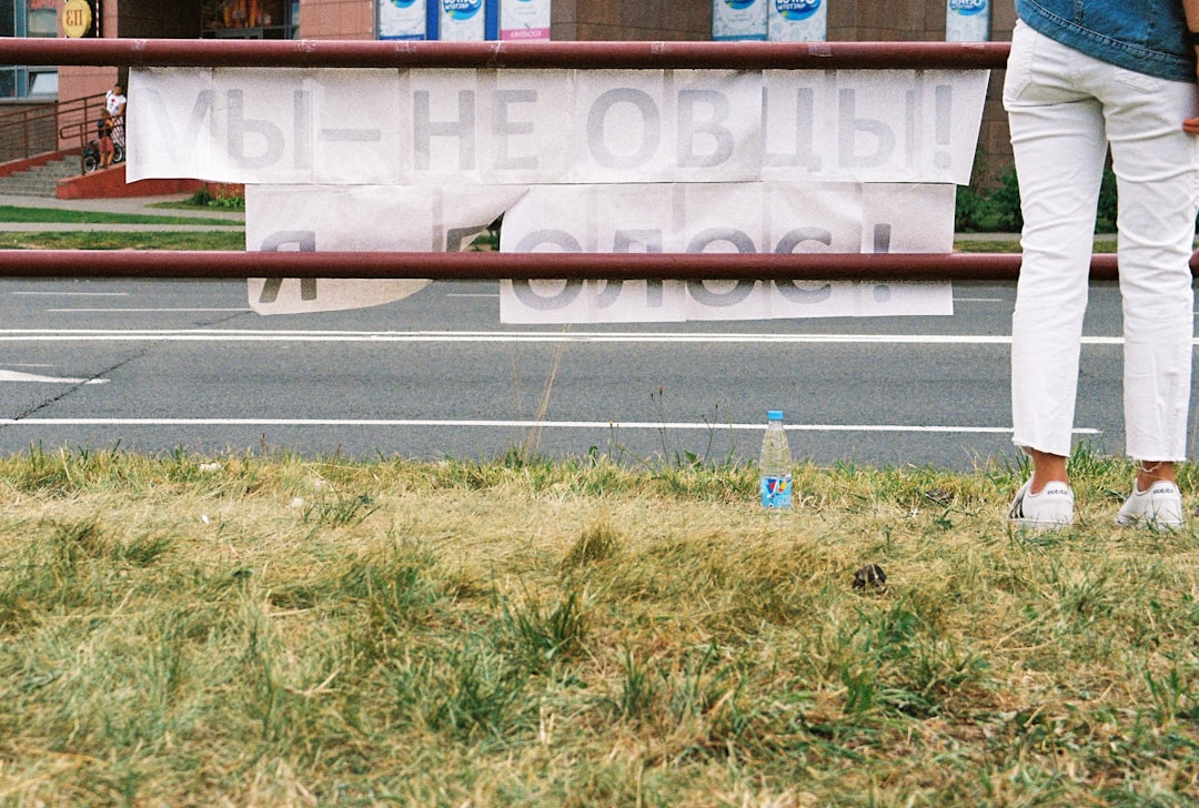 green grass field near white and red concrete building during daytime