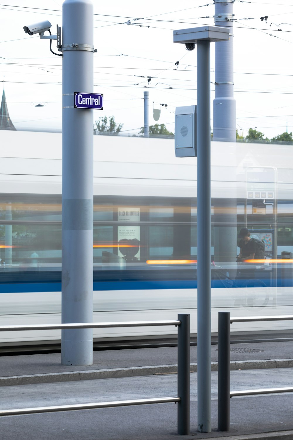 weiß-blauer Zug tagsüber am Bahnhof