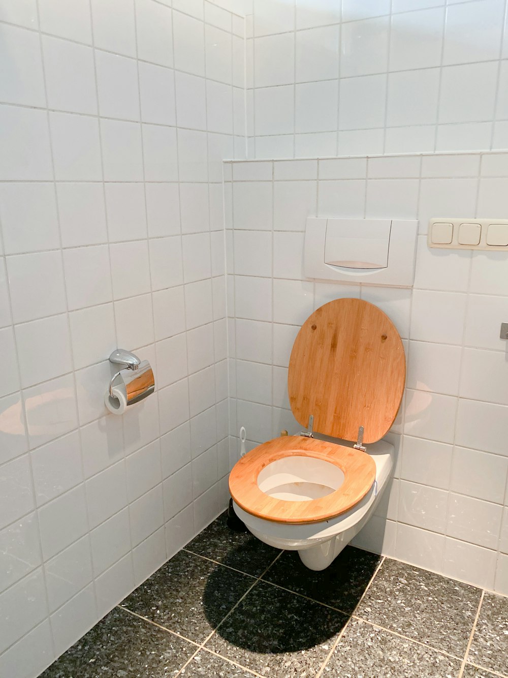 white ceramic toilet bowl beside white ceramic wall tiles