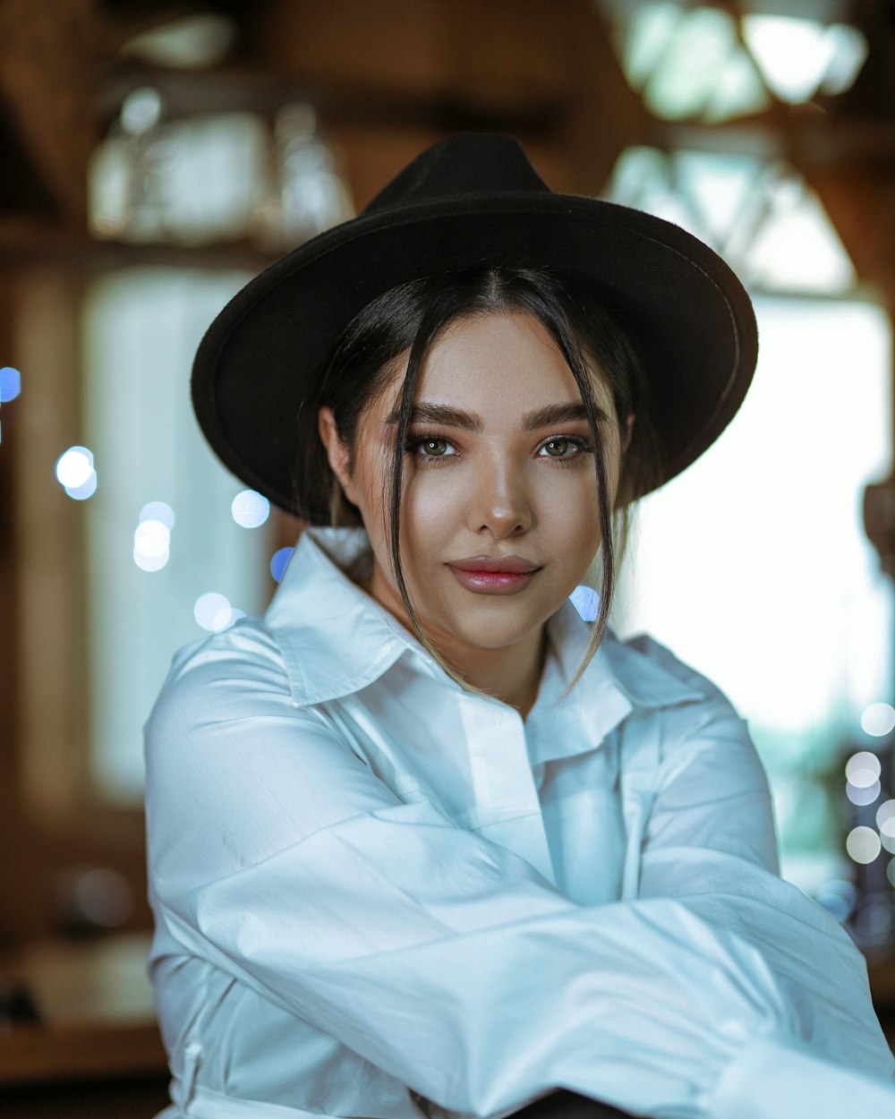 woman in white dress shirt wearing black hat