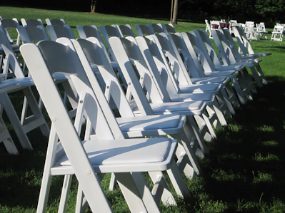 white folding chairs on green grass field