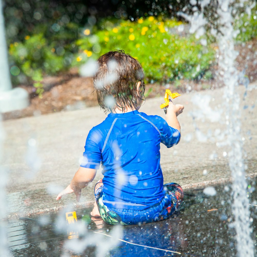 boy in blue t-shirt playing with water