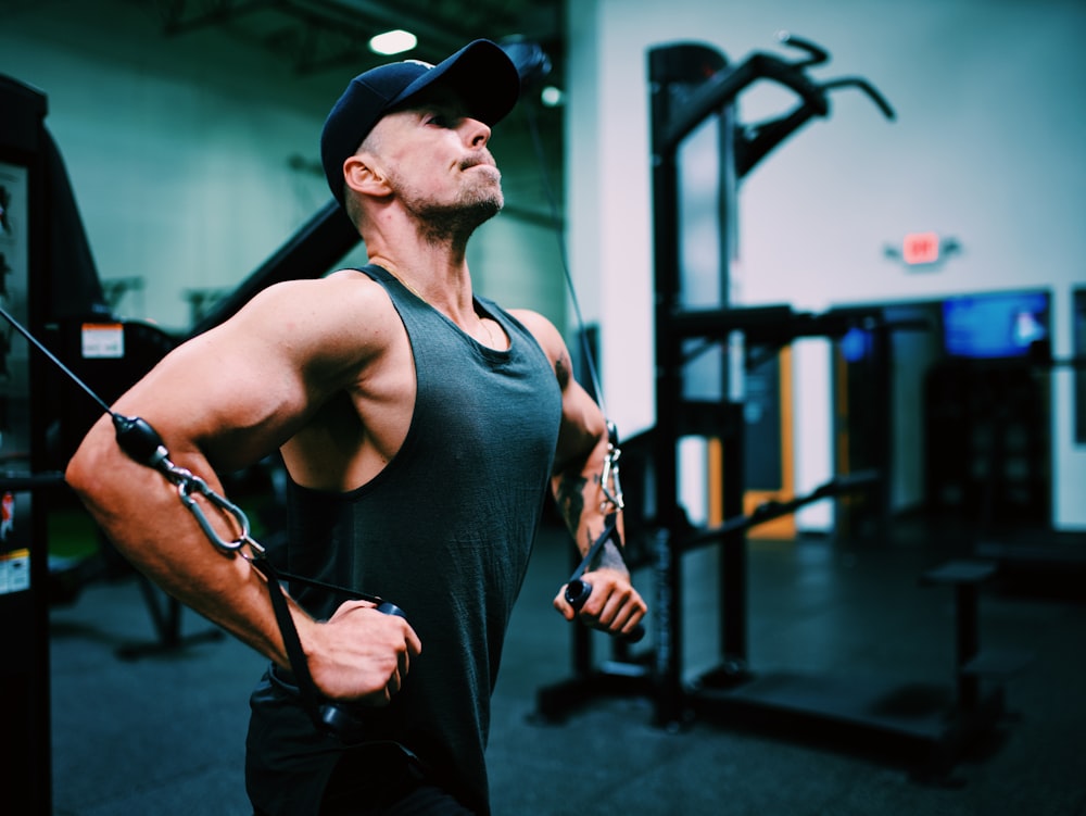 man in black tank top wearing black fitted cap