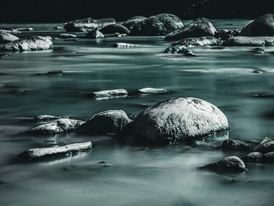 gray rock formation on body of water during daytime in Nehoiu Romania