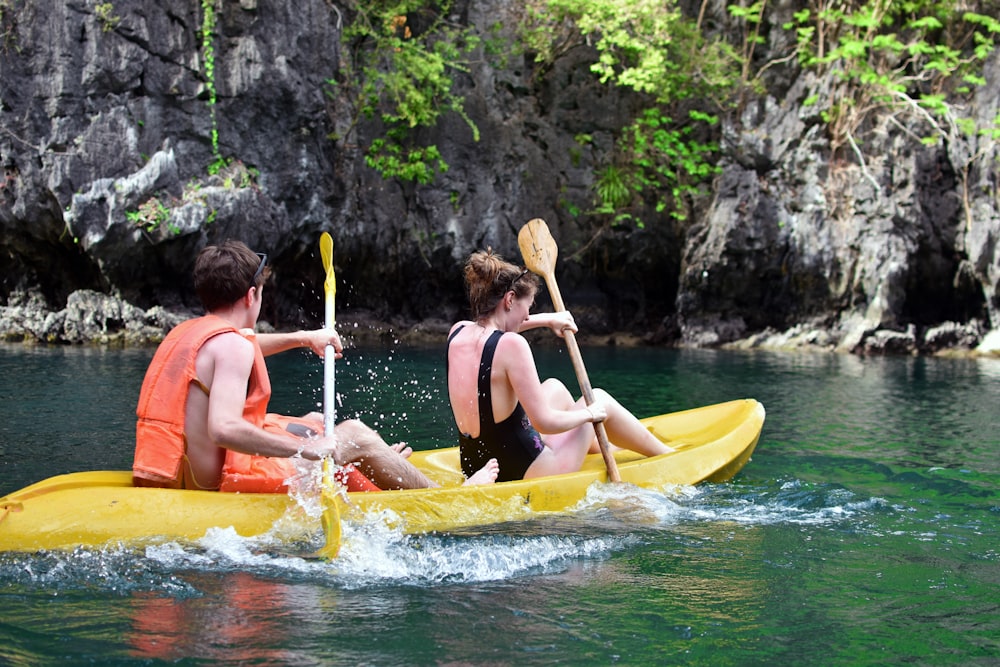 2 women in yellow kayak on river during daytime