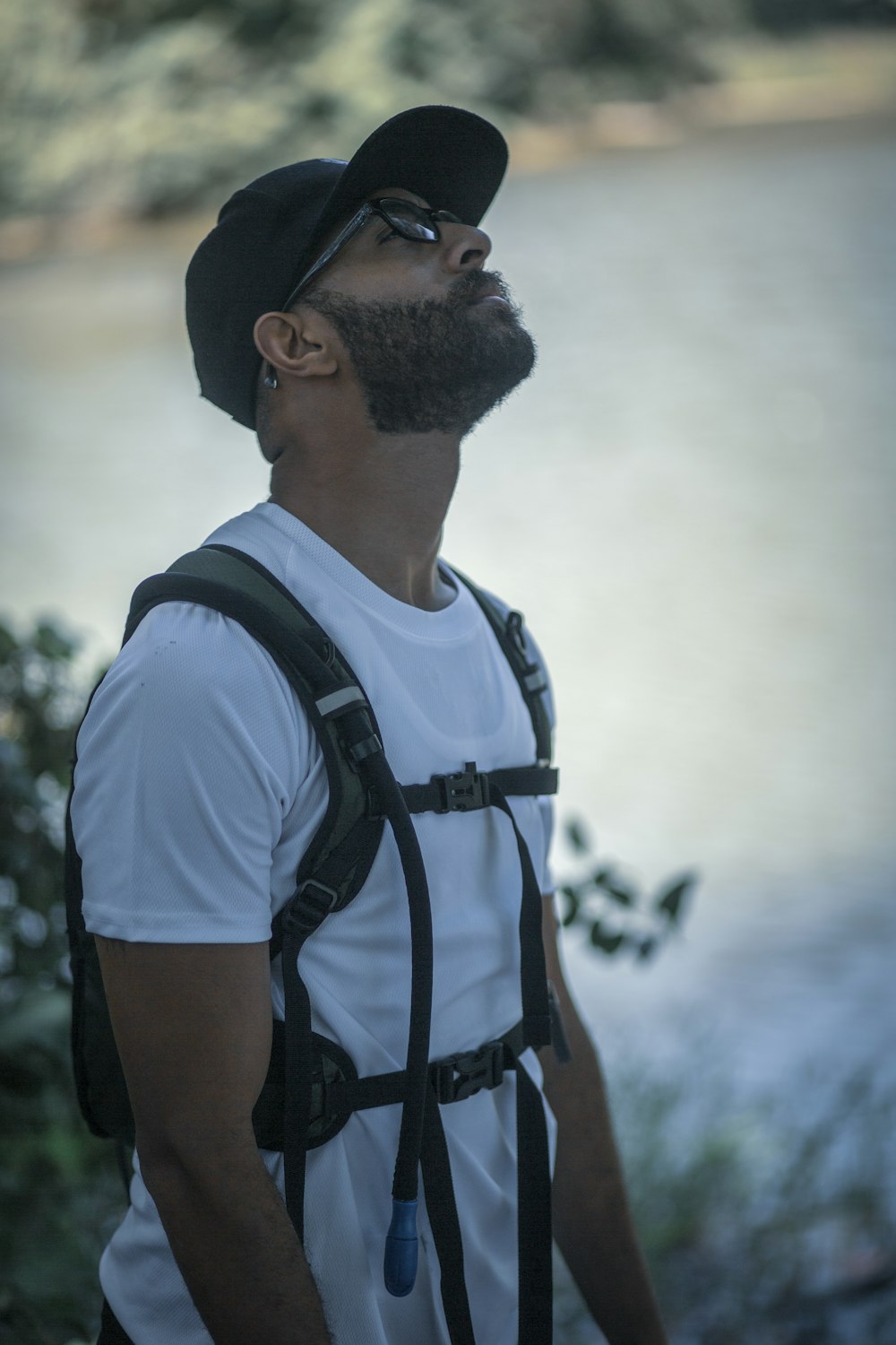 man in white t-shirt wearing black cap