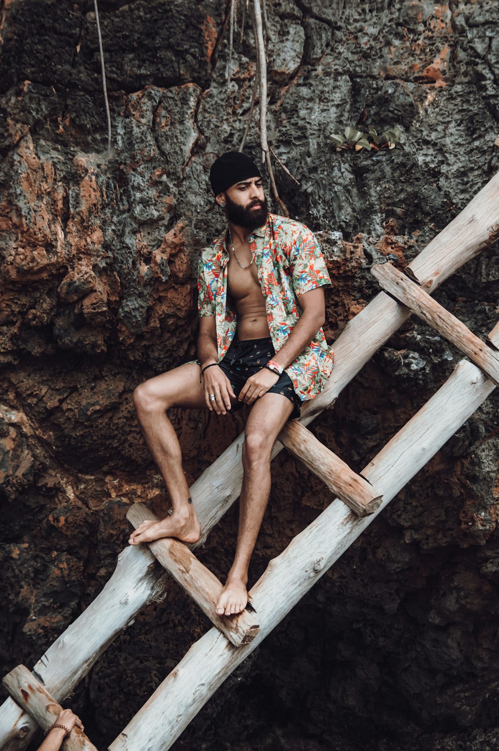 man in red and white plaid button up shirt sitting on brown wooden log