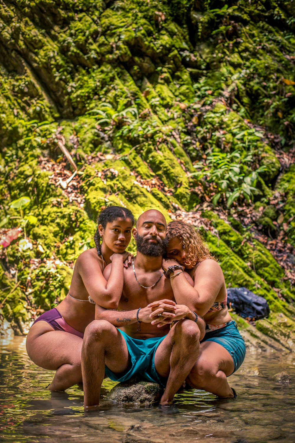 2 topless men sitting on blue textile on green grass during daytime