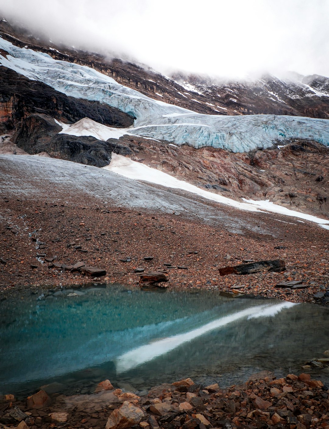 lake in the middle of snow covered mountains