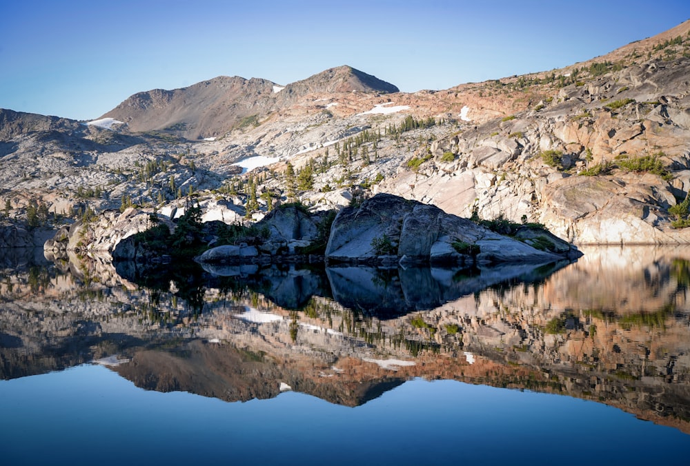 green and white mountain near body of water during daytime