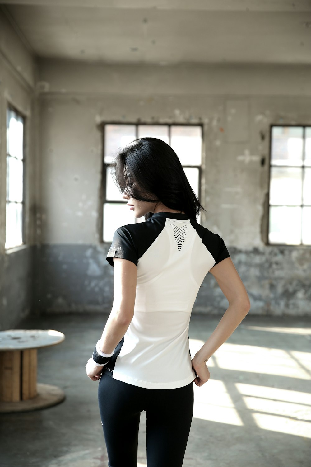 woman in white and black t-shirt sitting on brown wooden bench