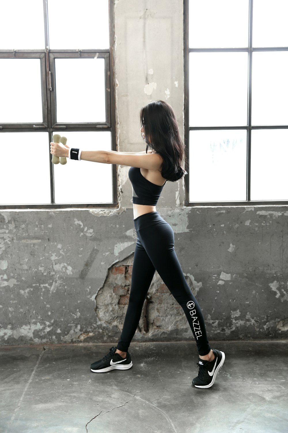 woman in black sports bra and black leggings holding bottle