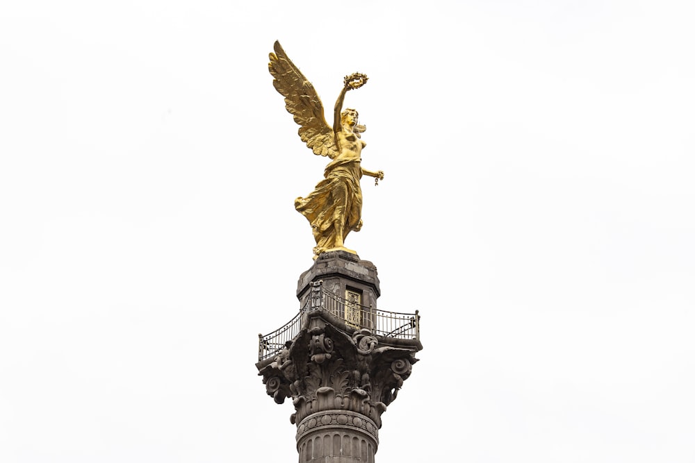 gold angel statue under white sky during daytime