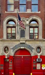 a red fire hydrant sitting in front of a fire station