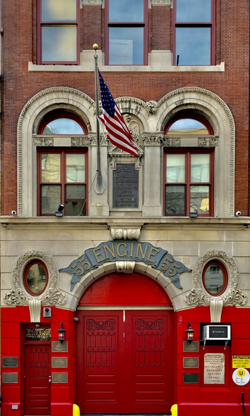 a red fire hydrant sitting in front of a fire station