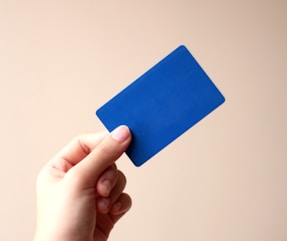 person holding blue card with white background
