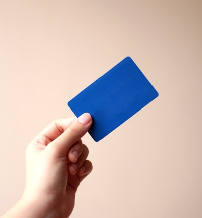 person holding blue card with white background