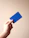 person holding blue card with white background