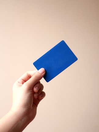 person holding blue card with white background