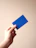 person holding blue card with white background