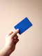 person holding blue card with white background