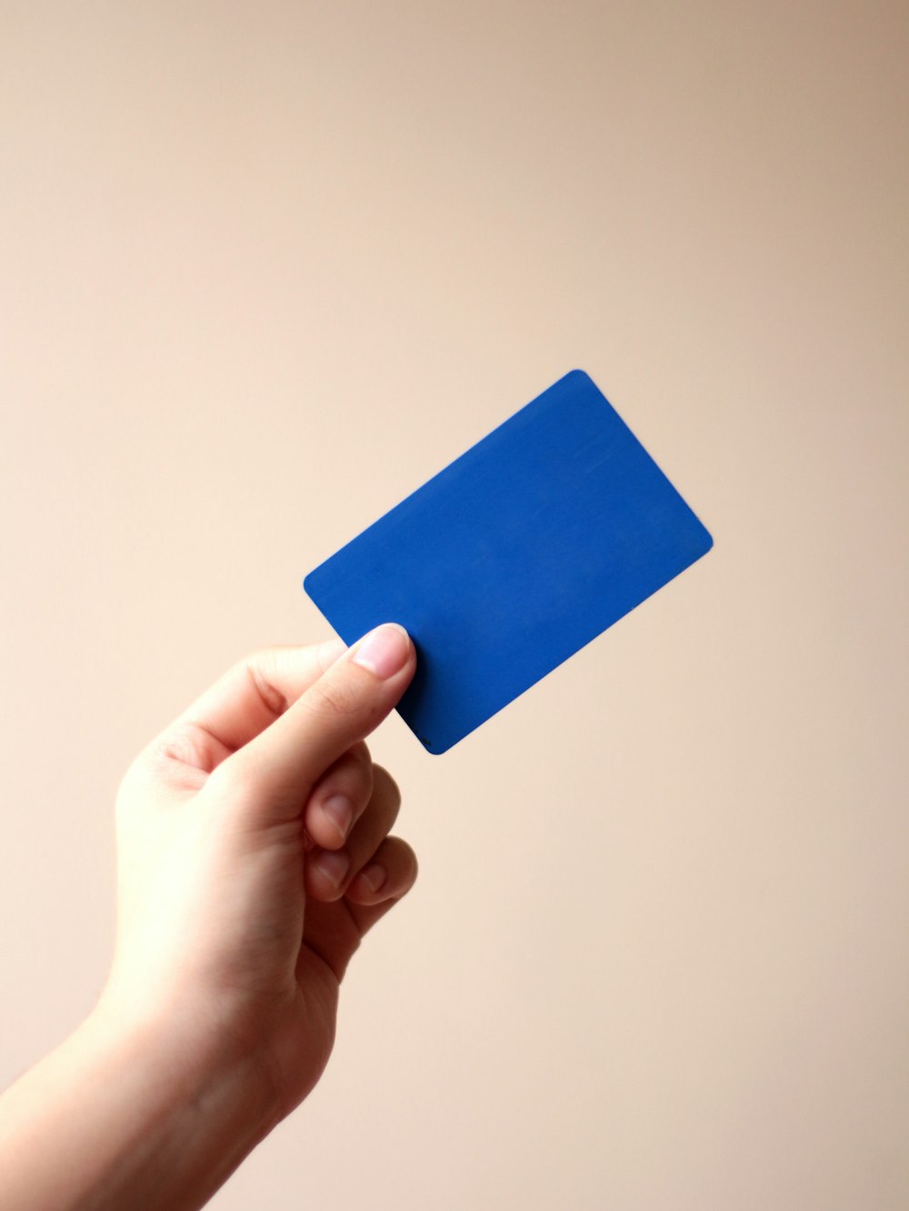 Persona in possesso di carta blu con sfondo bianco