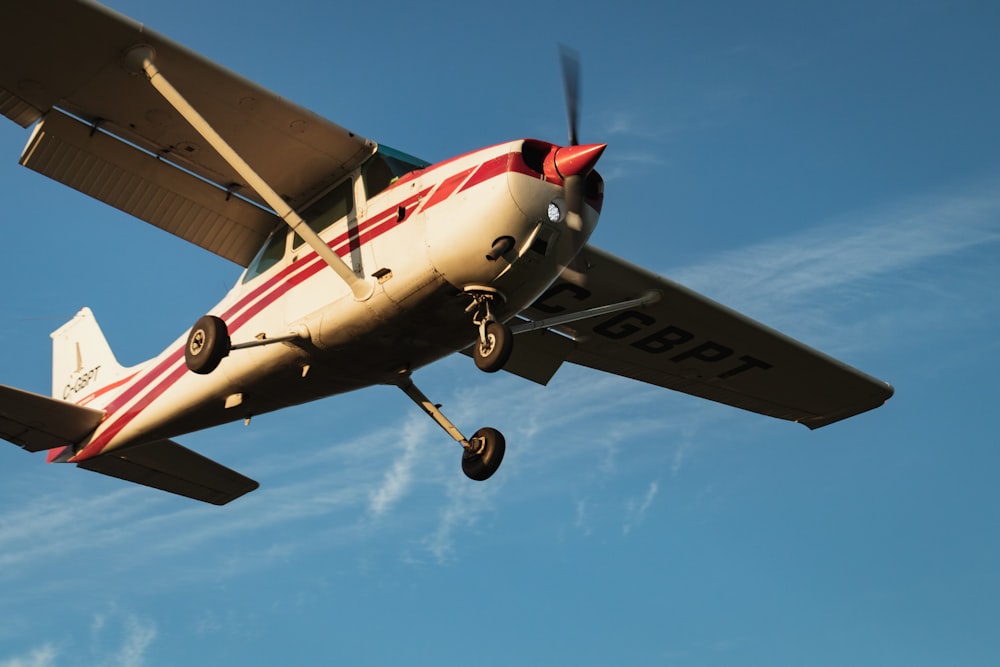 white and red airplane under blue sky during daytime