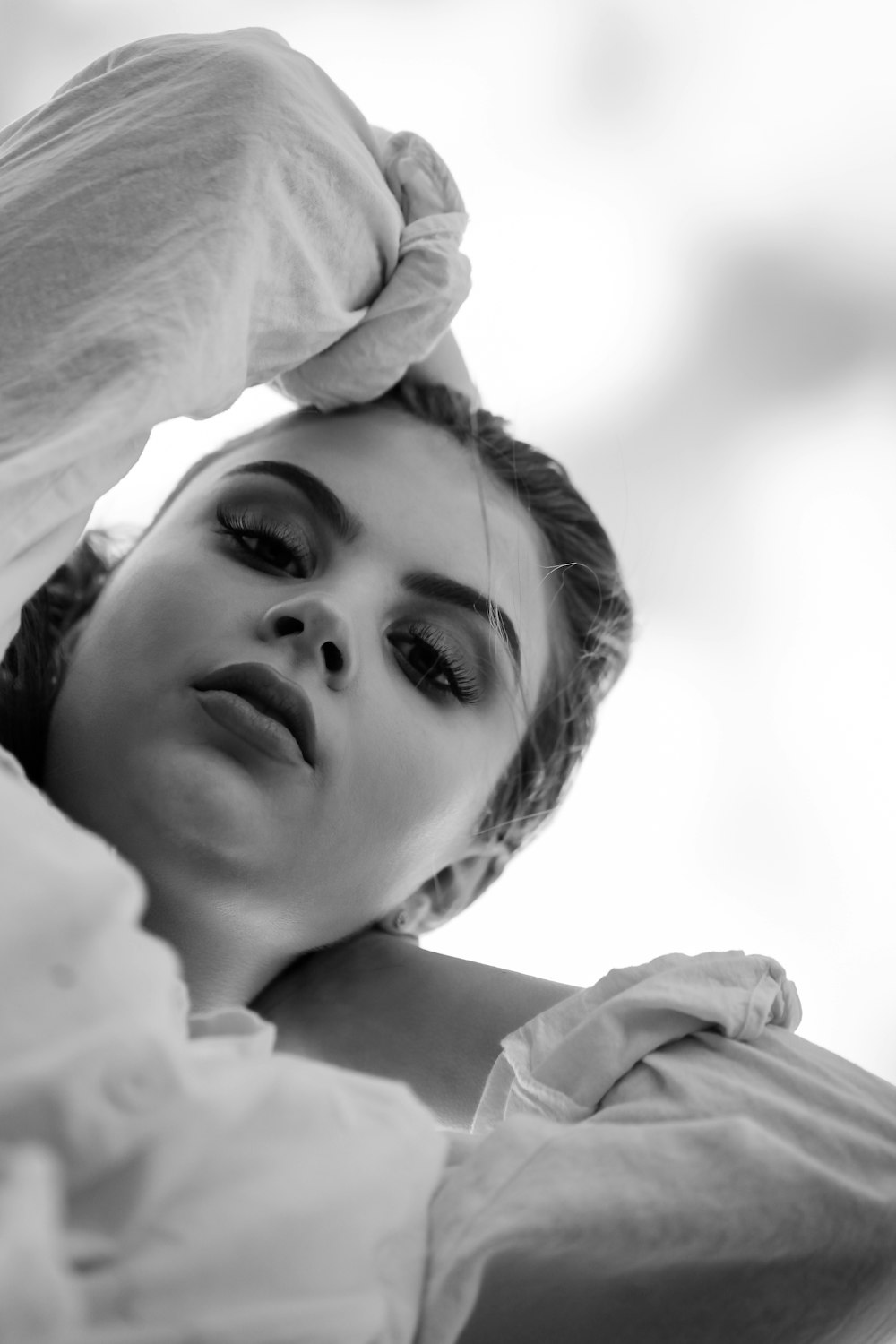 grayscale photo of girl lying on bed