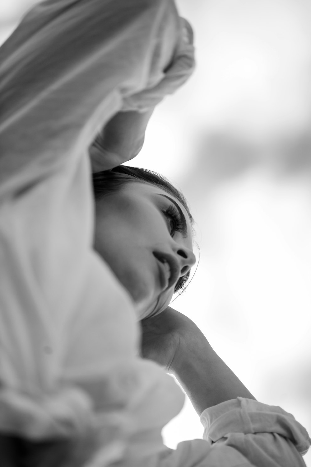 a woman in a white dress with her hands on her head