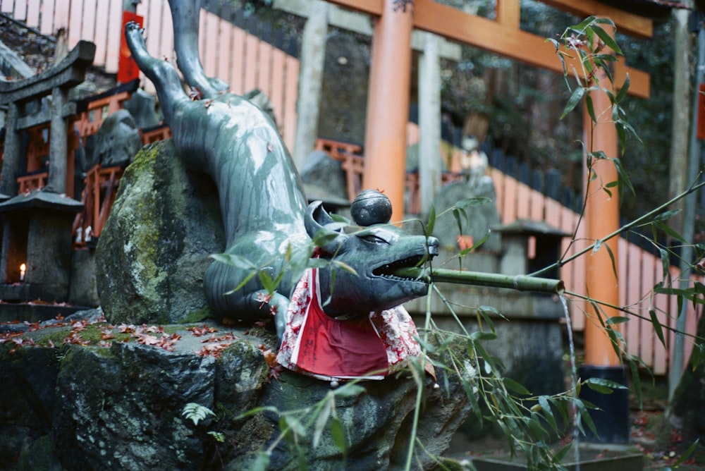 woman in red and red dress sitting on stone statue