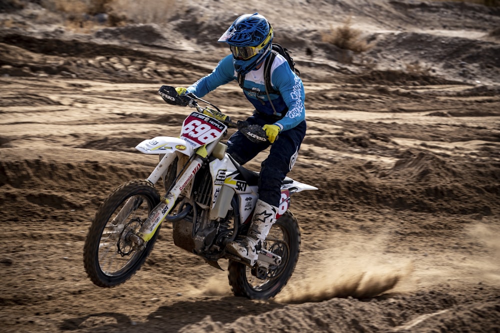 hombre en chaqueta azul y negra montando motocross dirt bike