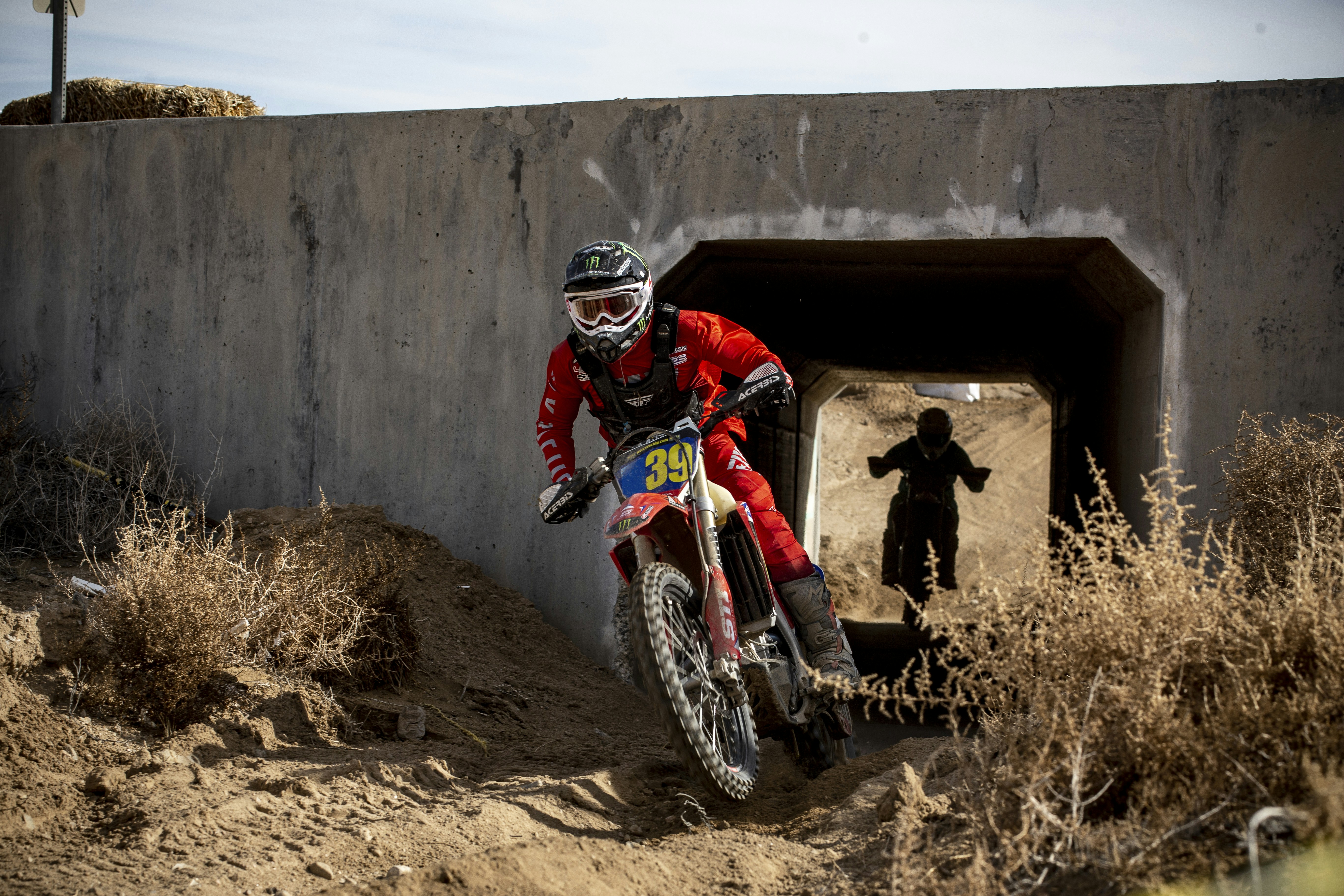 man in red and black motocross suit riding motocross dirt bike