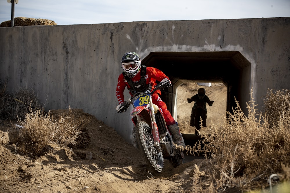 man in red and black motocross suit riding motocross dirt bike