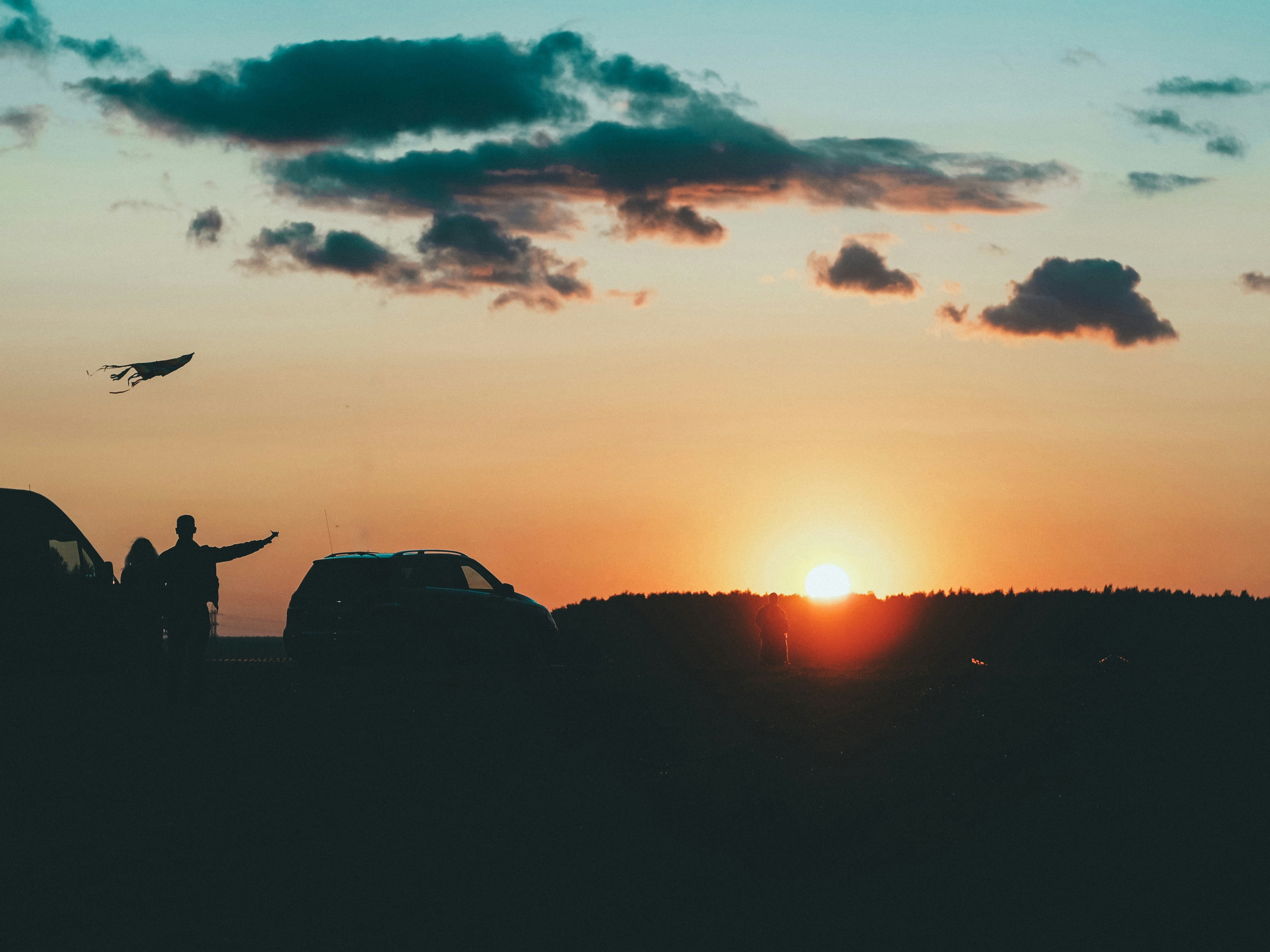 silhouette of man standing on rock formation during sunset