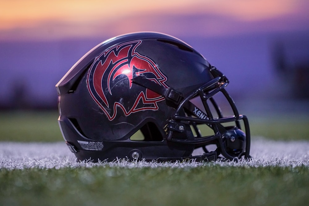 Casque de football rouge et noir sur herbe verte