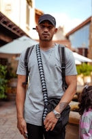 A modern man carrying a rivagi crossbody bag while walking through a city street, blending fashion with function.