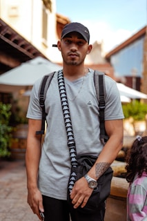 A modern man carrying a rivagi crossbody bag while walking through a city street, blending fashion with function.