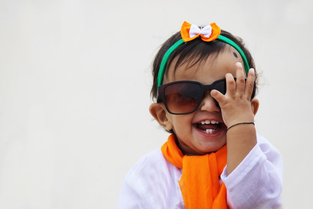 girl in white and orange hoodie wearing black sunglasses