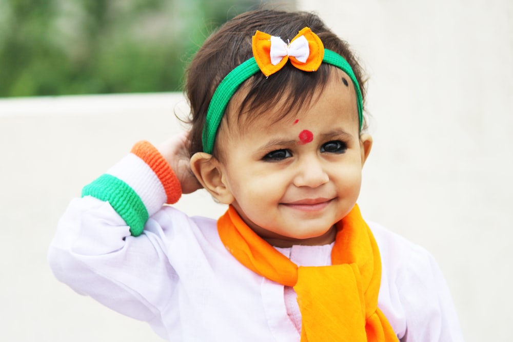 baby in white and orange long sleeve shirt