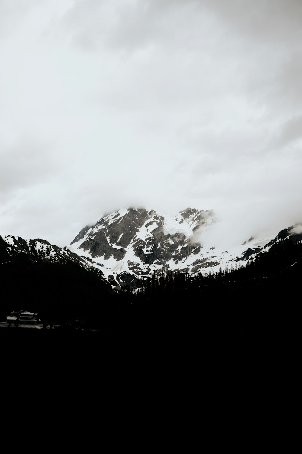 snow covered mountain under cloudy sky