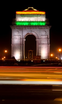 A vibrant stock market chart overlaying the iconic India Gate at sunset.
