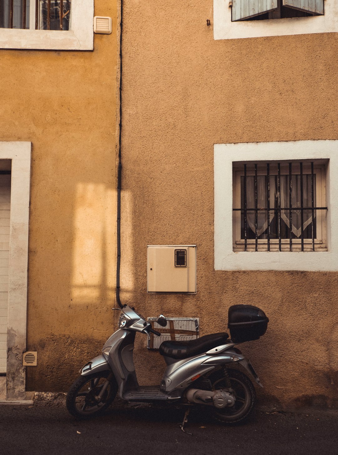 black motorcycle parked beside brown concrete building