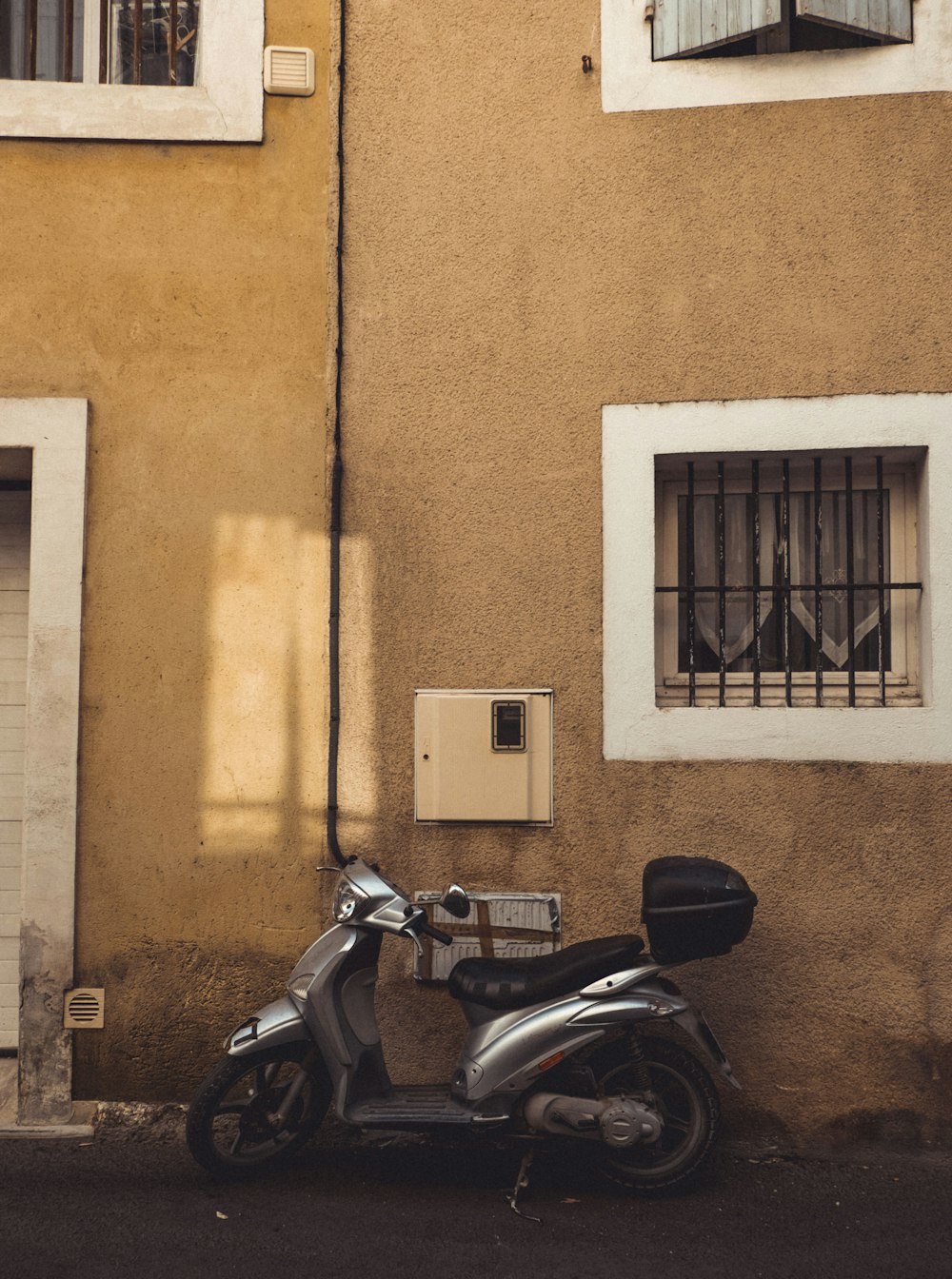 black motorcycle parked beside brown concrete building