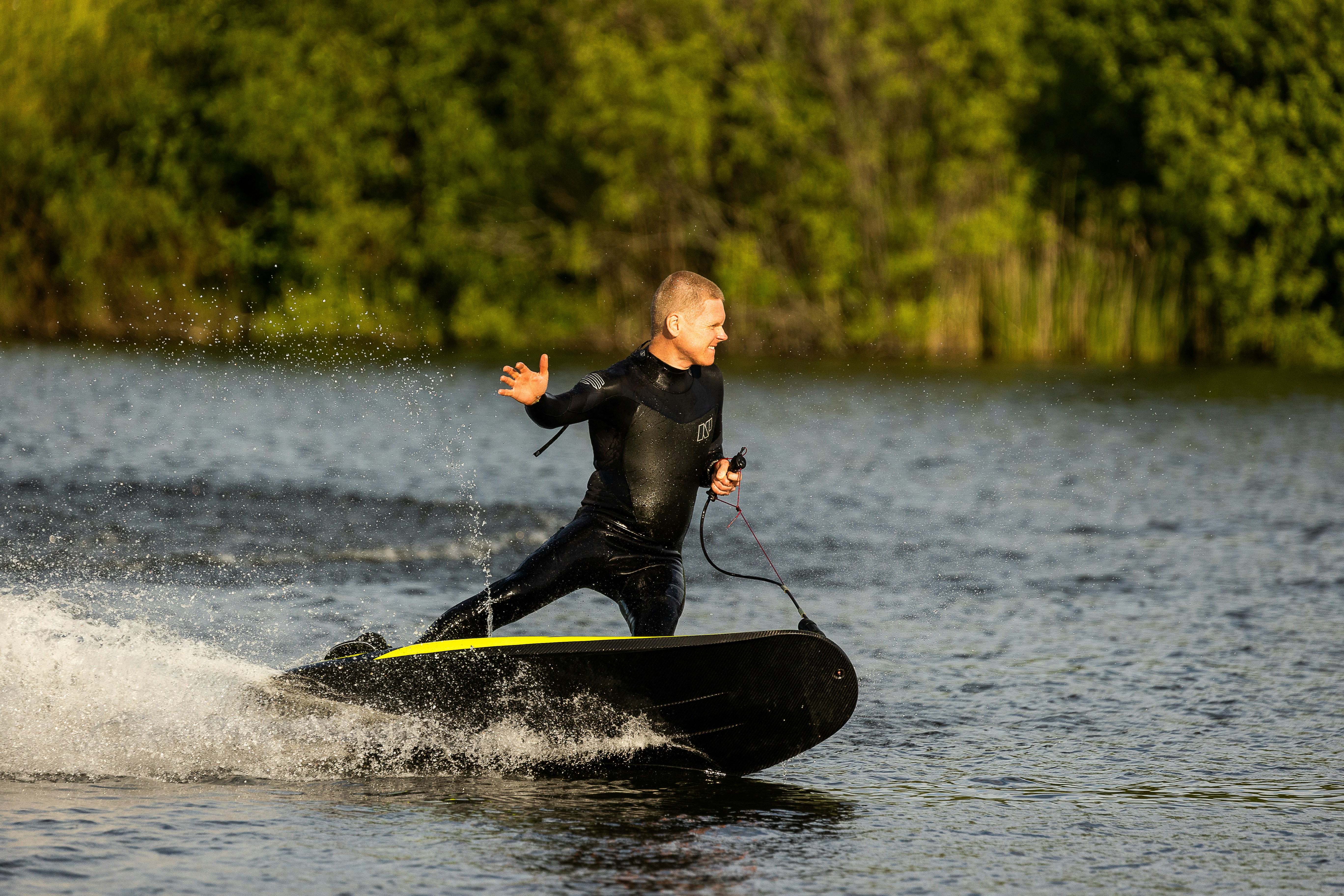 man in black wet suit riding on black and white boat during daytime