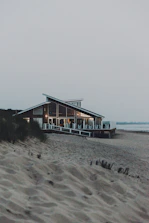 brown wooden house on beach during daytime