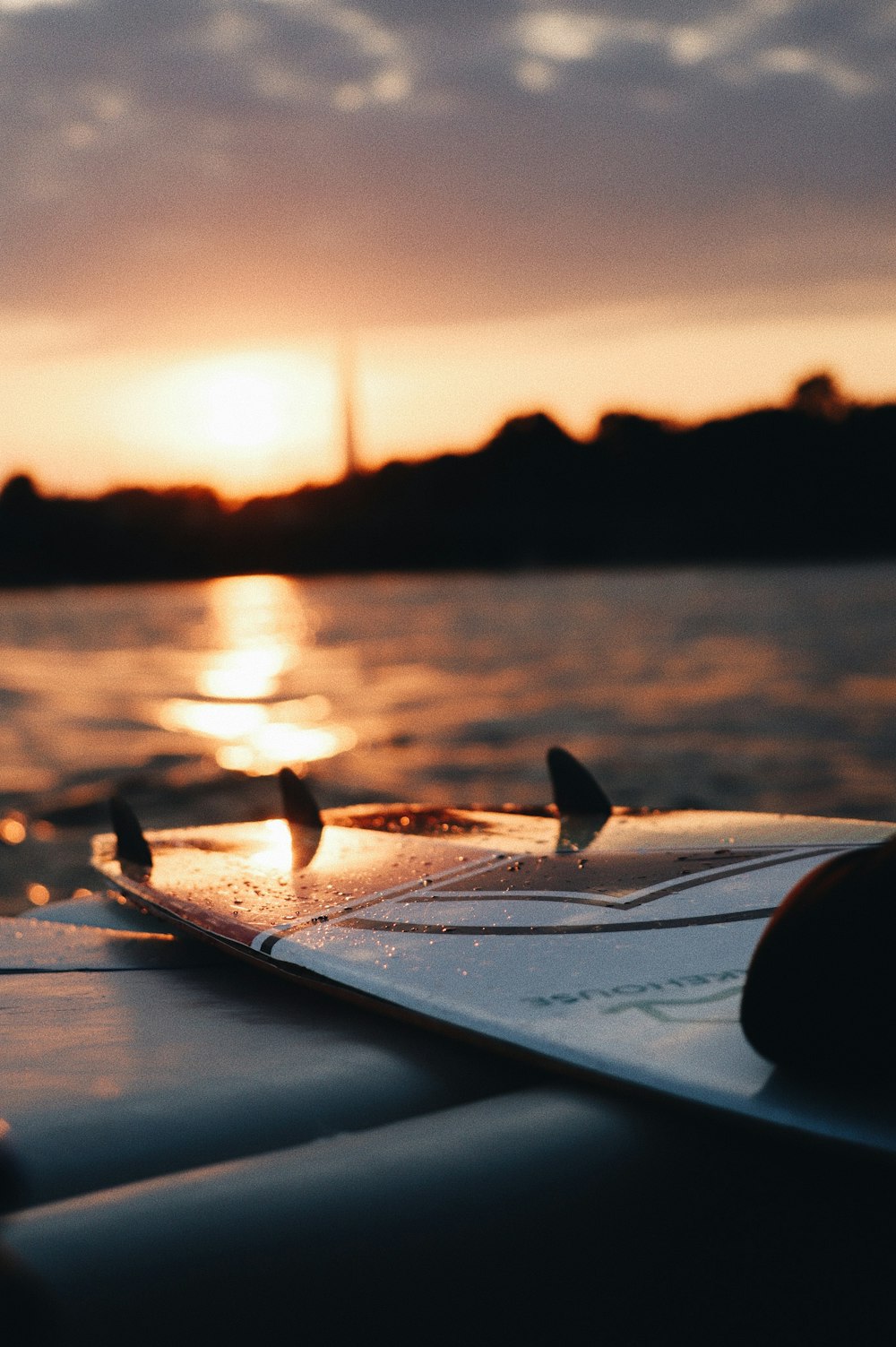 white surfboard on the beach during sunset