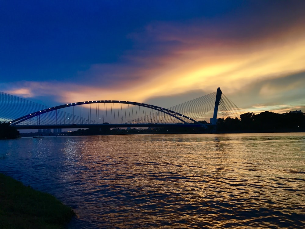 ponte sobre o corpo de água durante o pôr do sol