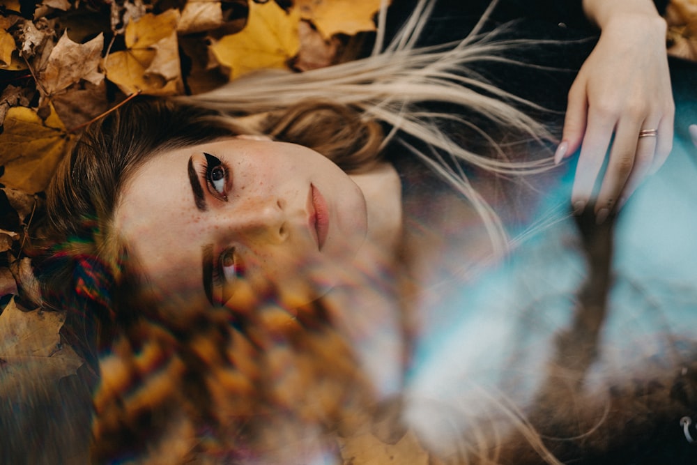 woman lying on brown leaves