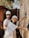 Two individuals wearing hard hats and protective eyewear are involved in construction work, assembling a wooden structure. They appear focused and collaborative, dressed casually with one of them smiling at the camera.